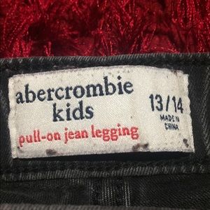 Grey jean leggings with rips on the knees.